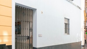 Un edificio blanco con una verja de metal y un ventanal pequeño.