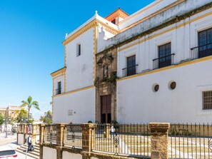 Edifici històric amb façana blanca, entrada central amb una estàtua i un balcó al segon pis.