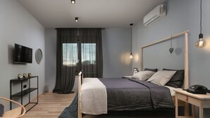 Un dormitorio moderno con cama, mesita de noche y televisión en la pared.