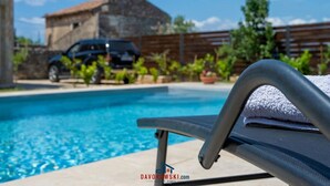 A swimming pool with a lounge chair and a car parked in the background. - Boky Comfortable Holiday Residence (Vodnjan)