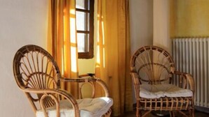 Two wicker chairs with cushions, a window with curtains, and a radiator on a tiled floor. - Nice Apartment in Trassenheide (Bonvicino)
