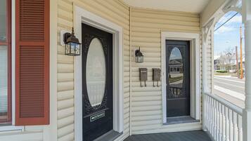 A porch with a black door marked "ENTRANCE" and a small mailbox.