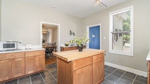 A modern kitchen with wooden cabinets, a central island, and a microwave. - Gettysburg Home sleeps 10 with parking and Game Room.  Just off the square. (Gettysburg)