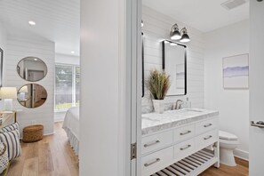 A modern bathroom with a white vanity, a large mirror, and a toilet. - 1590 Lagoon Villas at The Sea Pines Resort (Hilton Head Island)