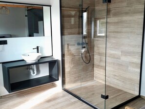 A modern bathroom with a glass-enclosed shower, a white sink, and a black shelf. - Luxurious Villa in a Residential Location (Koksijde)