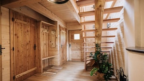 A wooden interior with a staircase, wooden doors, and a plant.