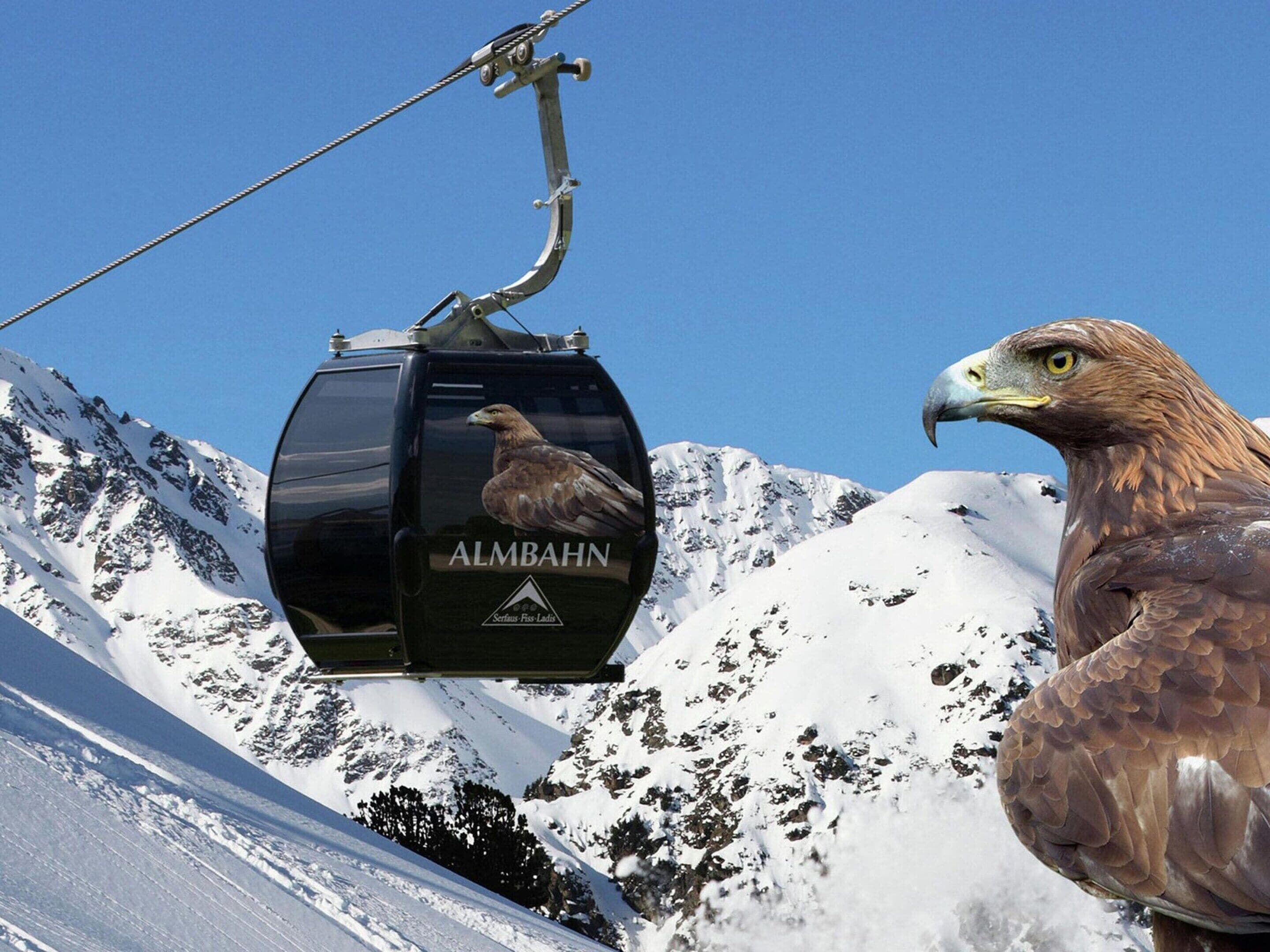 A cable car with 'ALMBAHN' branding and a mountain backdrop.