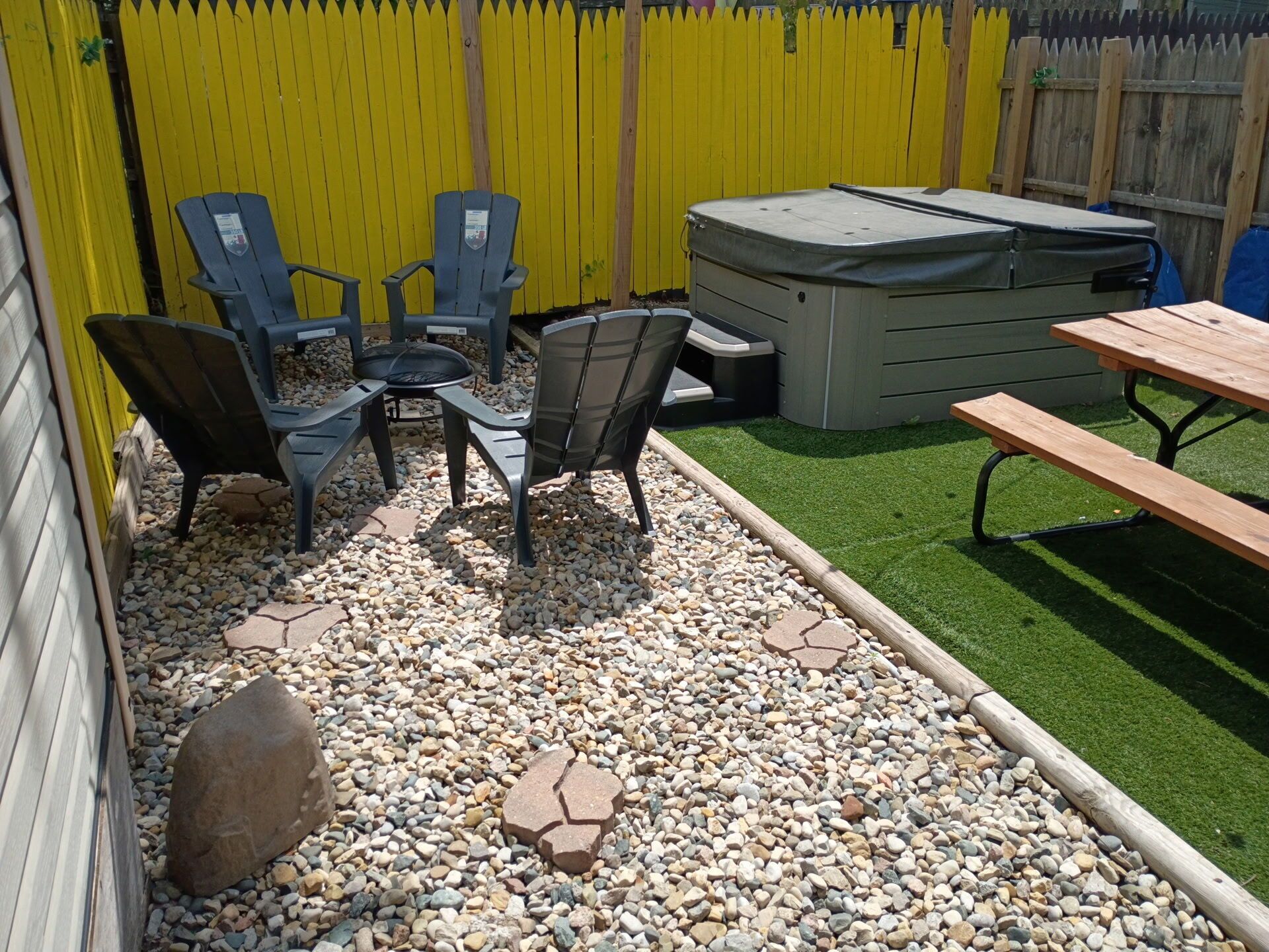 Une terrasse avec des meubles d’extérieur, un jacuzzi et une table en bois.