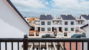 A residential area with white houses, some with balconies, under a partly cloudy sky. - Spacious Vacation Home in Corralejo (La Oliva)