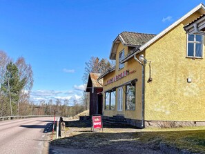 A yellow building with a sign reading 'GUSTAFSONS' and a red signboard with 'ÖPPET' on it. - 4 Person Holiday Home in Hoje (Höje)