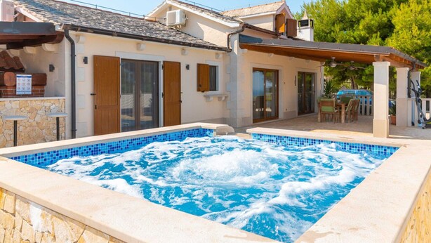 Ein Wohnhaus mit Schwimmbad, Außenbereich und überdachter Terrasse.
