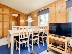 A wooden-paneled room with a dining table, chairs, a television, and a lamp. - 6 Person Holiday Home in Rodvig Stevns (Rodvig Stevns)