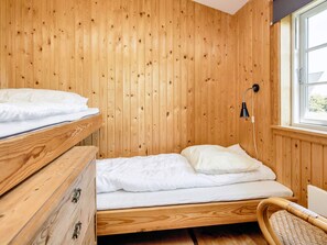 A wooden room with a bunk bed, a bedside table, a lamp, and a window. - 6 Person Holiday Home in Rodvig Stevns (Rodvig Stevns)