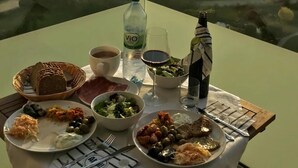 A table with a meal set on a balcony overlooking a coastal view. - Lovely Apartment in Neustadt (Neustadt in Holstein)