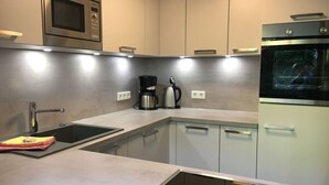 A modern kitchen with stainless steel appliances, a built-in oven, and a coffee maker. - Postwiese Comfortable Holiday Residence (Winterberg)