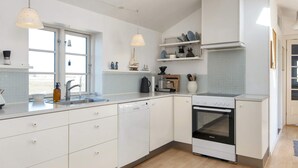 A modern kitchen with white cabinets, a built-in oven, and pendant lights. - 10 Person Holiday Home in Harboore (Harboore)