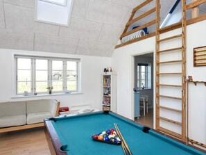 A room with a pool table, a sofa, a bookshelf, and a loft area with a ladder. - 10 Person Holiday Home in Harboore (Harboore)
