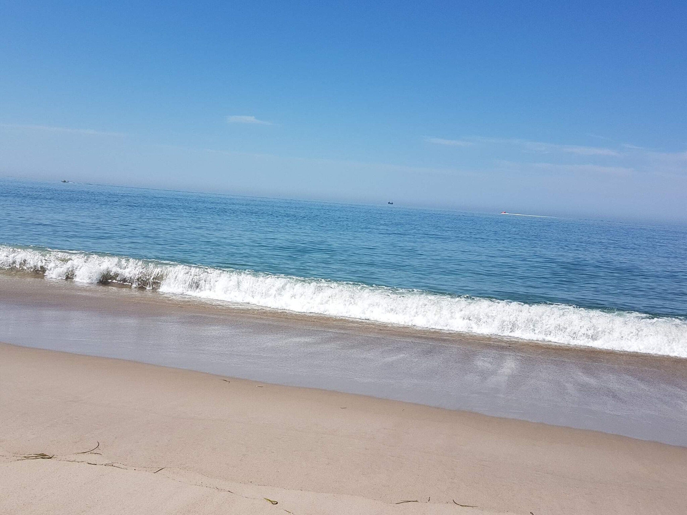 A beach with a clear sky and calm sea.