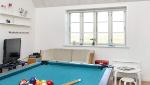 A room with a pool table, a television, a window with a view, and a small table with a magazine. - 10 Person Holiday Home in Harboore (Harboore)