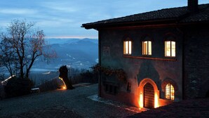 A historic building with arched windows and a brick facade, overlooking a valley. - Apartment in a Famous Monferrato Castle (Gabiano)