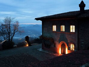 A historic building with arched windows and a brick facade, overlooking a valley. - Apartment in a Famous Monferrato Castle (Gabiano)