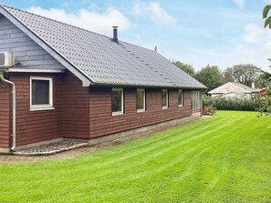 A single-story house with a sloped roof, a chimney, and a well-maintained lawn. - 4 Star Holiday Home in Farso (Farso)
