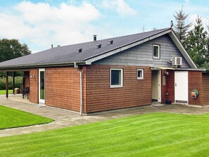 A single-story building with a sloped roof, a covered porch, and a small attached garage. - 4 Star Holiday Home in Farso (Farso)