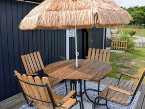 A round wooden table with metal legs, surrounded by six wooden chairs with metal frames. - 5 Person Holiday Home in Falkenberg (Falkenberg)