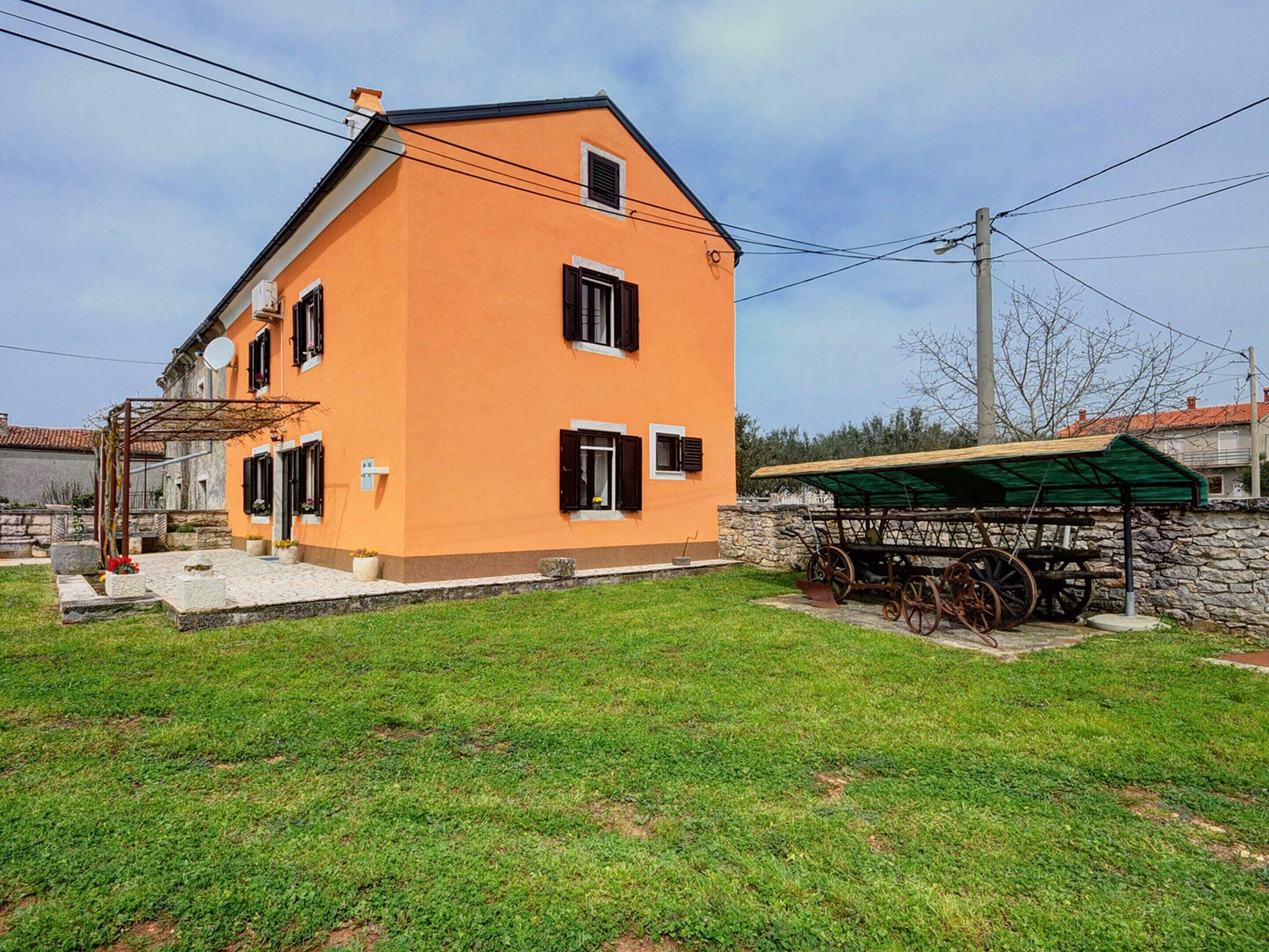 A two-story house with a sloped roof and a stone foundation.