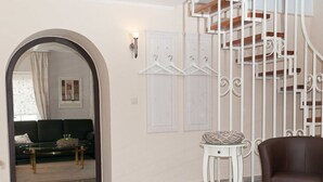 A living room with a staircase, a sofa, a coffee table, and a chair. - Casa Schalkenmehren Grande (Schalkenmehren)