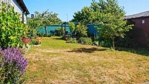 A residential area with a grassy yard, a blue building, and a red building. - 4 Star Holiday Home in Visby (Visby)
