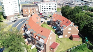 Un quartier résidentiel avec des immeubles modernes, un port de plaisance et un pont en arrière-plan.