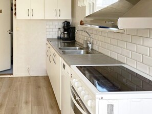 A kitchen with a built-in stove, a coffee maker, and a sink.