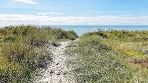 A sandy path leading to a body of water, surrounded by grassy vegetation. - 4 Star Holiday Home in Solvesborg (Sölvesborg)