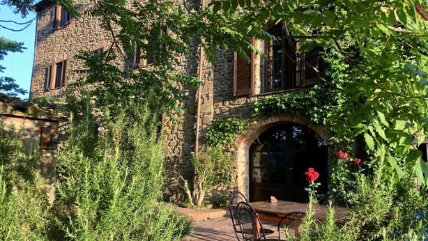 A rustic stone building with a wooden table and chairs in the foreground, surrounded by greenery and a stone wall. - Holiday Apartment Casa Felicita (Gavorrano)