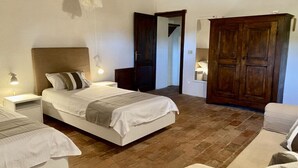 A bedroom with a bed, bedside tables, a wardrobe, and a hanging light fixture. - Holiday Apartment Casa Felicita (Gavorrano)