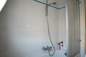 Un baño con ducha, bañera y retrete.