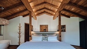 A bedroom with a large bed, wooden ceiling beams, and a rustic decor style. - Chalet Alpin Comfortable Holiday Residence (Bayrischzell)