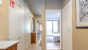 A hotel corridor with a wooden floor, a marble counter, and a bed in the adjacent room. - Apartment With a Beautiful Terrace and sea View (Middelkerke)