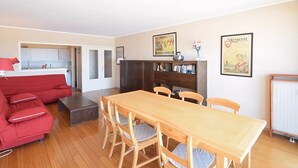 A compact living space with a dining area, kitchenette, and a red sofa. - Apartment on Belgian Coast With Sea View (De Haan)