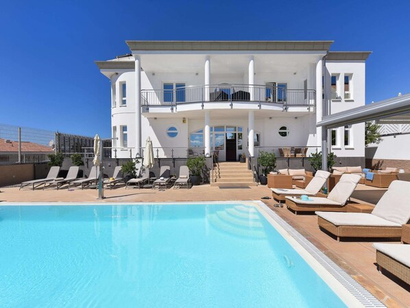 A two-story building with a swimming pool, outdoor seating, and a covered area. - Belvilla by OYO Villa Doramas 12 pax (Mogan)