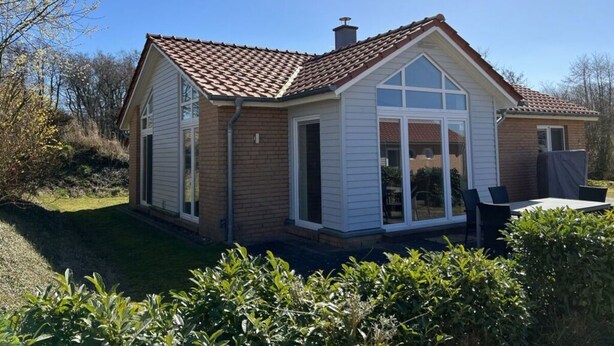 A two-story house with a tiled roof, a chimney, and a large front window. - Northern Light House (Kosel)