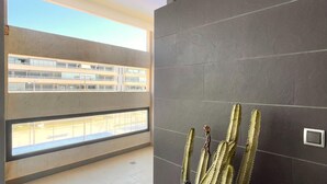 Un interior moderno con un ventanal amplio que da a un conjunto de edificios.