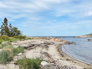 A coastal landscape with a sandy beach, rocky outcrops, and sparse vegetation. - 4 Star Holiday Home in Grisslehamn (Grisslehamn)
