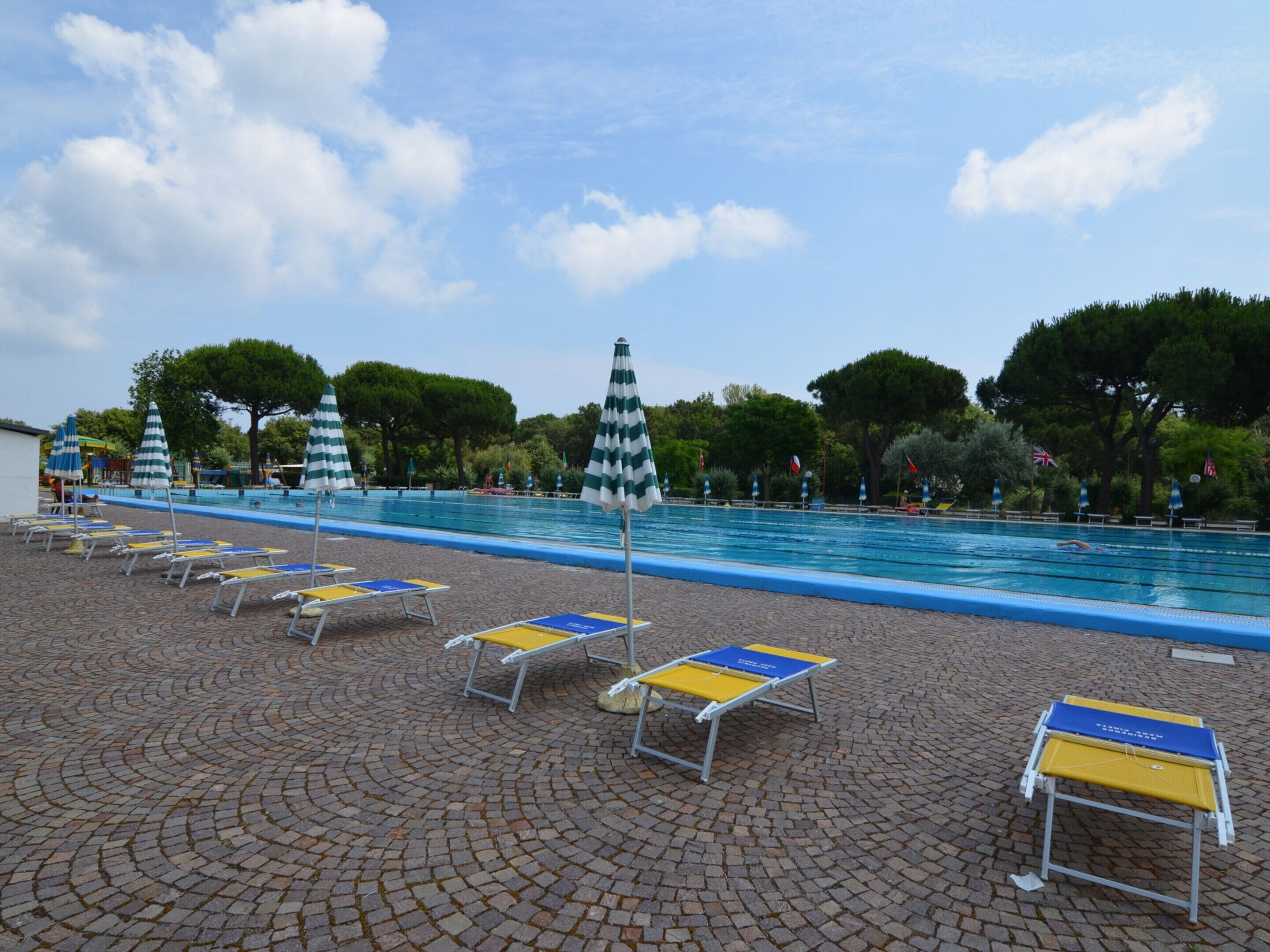 Area piscina con lettini e ombrelloni.