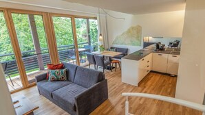 A modern apartment with a balcony, a dining area, and a kitchen. - Suite Apartment 80 sqm (Gaienhofen)