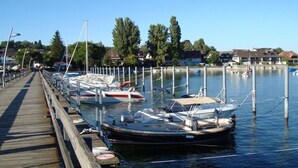 A wooden pier extending into calm water with several boats docked at the marina. - Suite Apartment 80 sqm (Gaienhofen)