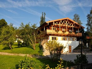 A traditional chalet with a wooden balcony, surrounded by lush greenery and a clear sky. - Chestnut in Chalet Bergerhoh (Bad Wiessee)