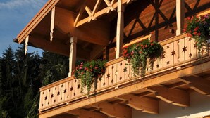 Un balcone in legno con ringhiere a forma di stella e fioriere.