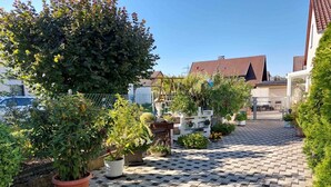 Ein gepflasterter Innenhof mit Blumentöpfen und blauem Himmel.